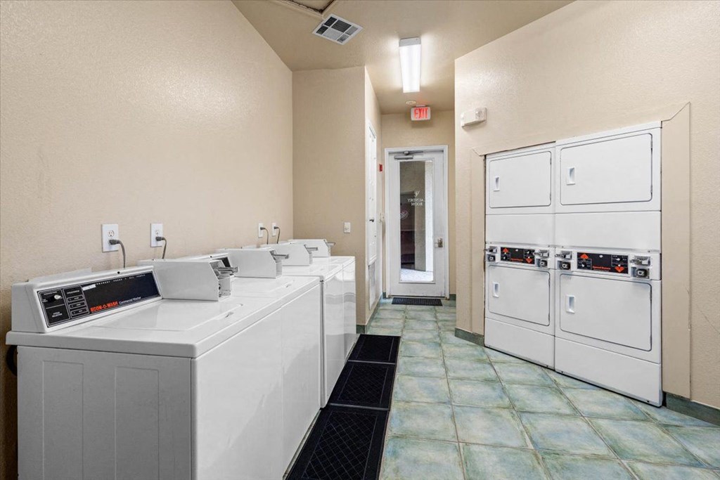 a laundry room with four washers and two dryers