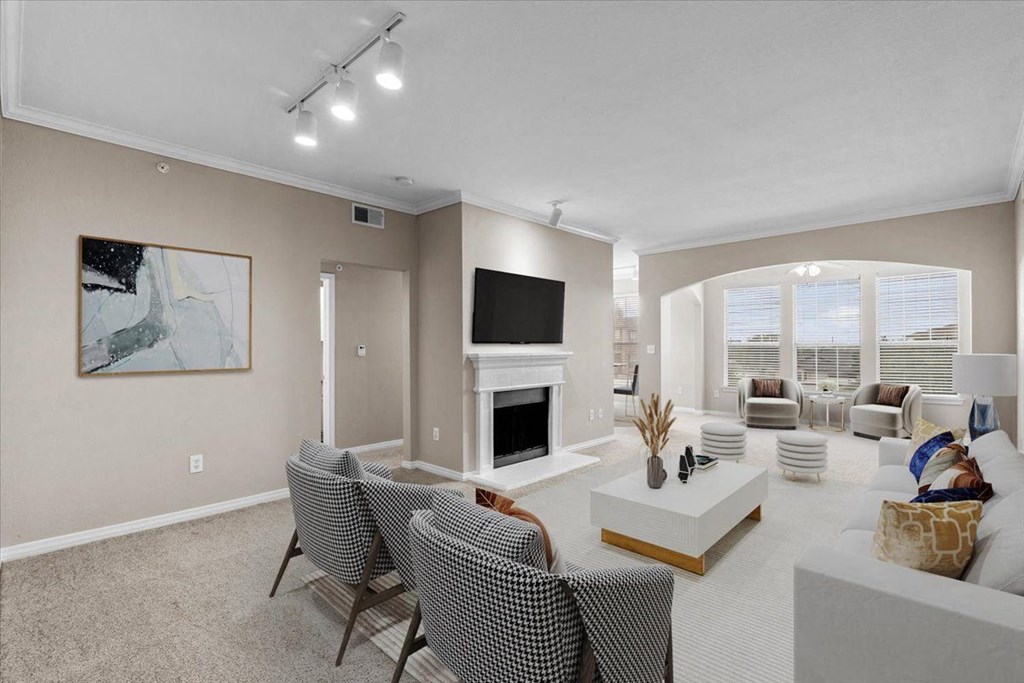 a living room with a fireplace and a large window at The Clairborne Apartment Homes, Grand Prairie, TX