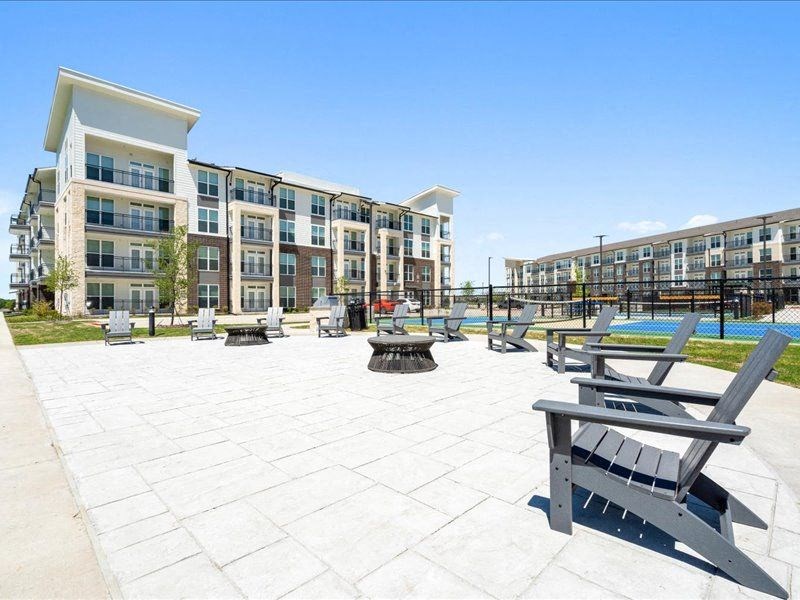 an outdoor seating area with benches and buildings in the background
