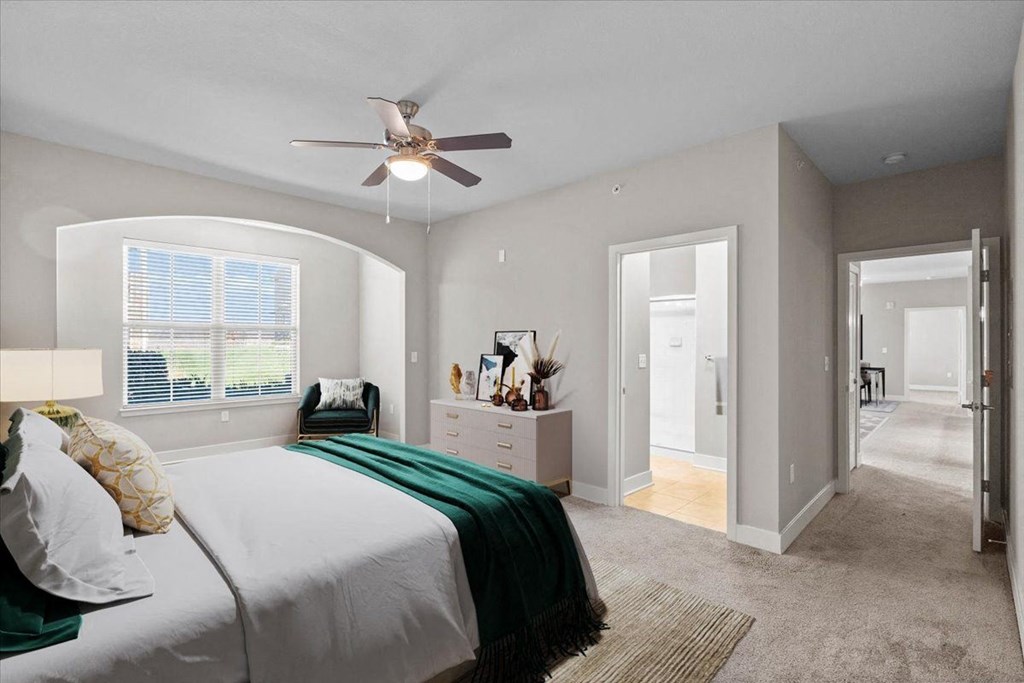 a bedroom with a bed and a ceiling fan