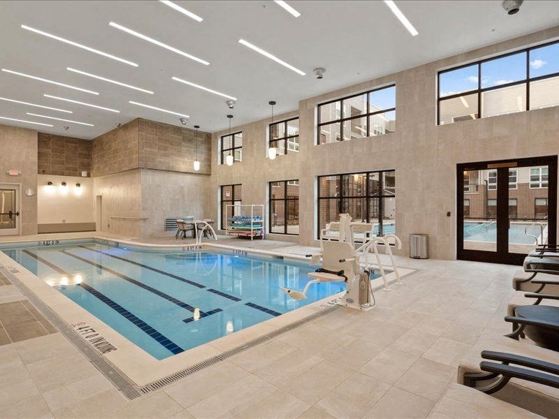 a swimming pool in the middle of a building with chairs