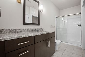 A bathroom with a marble countertop and a large mirror.
