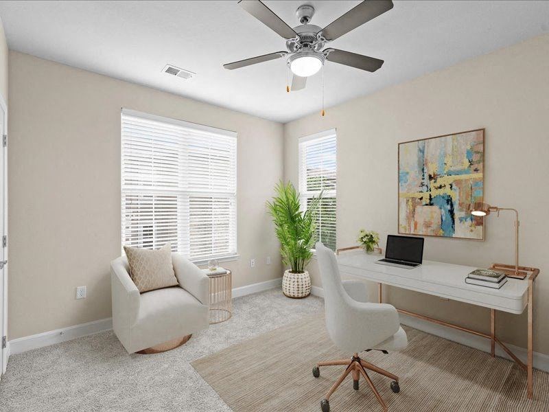a room with a desk and a chair and a ceiling fan