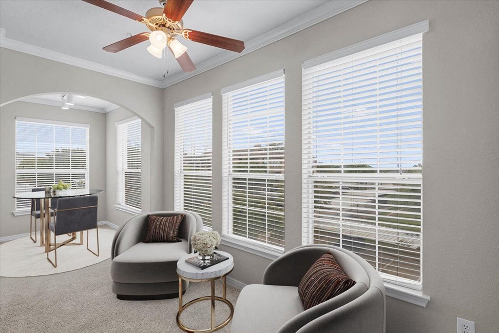 a living room with four windows and a ceiling fan at The Clairborne Apartment Homes, Grand Prairie, TX, 75050