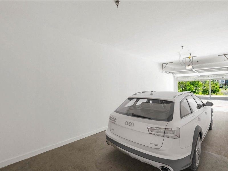 a white car parked in a white garage