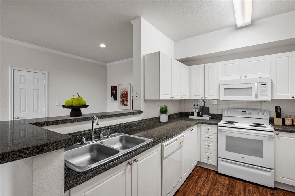 a kitchen with white cabinets and a granite counter top