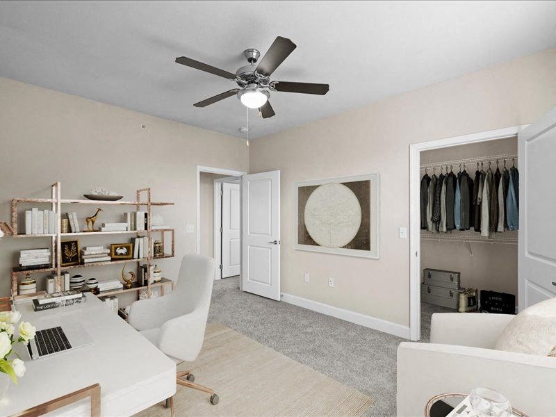 an office with a ceiling fan and a closet