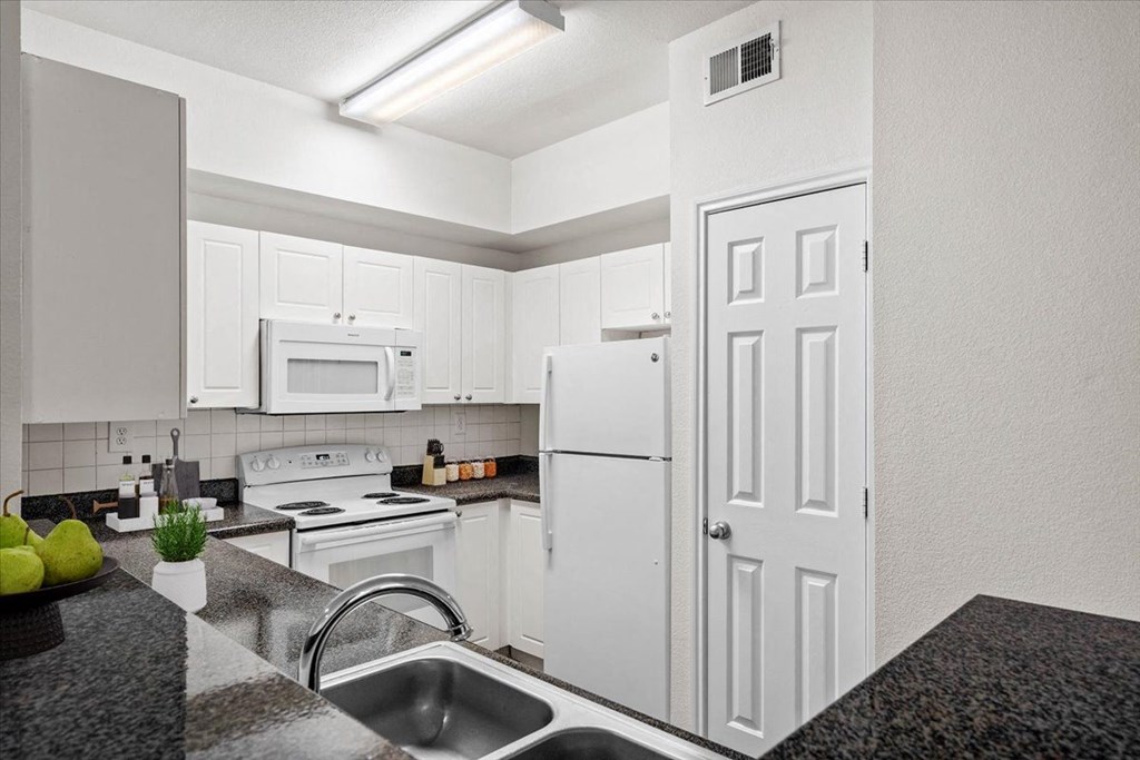 a kitchen with white cabinets and white appliances