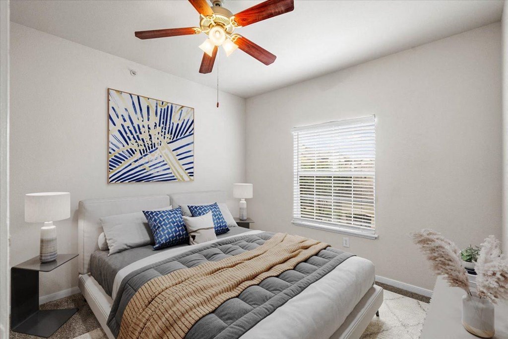a bedroom with a bed and a ceiling fan