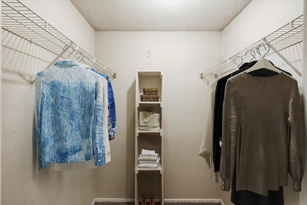 a walk in closet with two racks and a closet organizer at Pear Ridge, Dallas, Texas