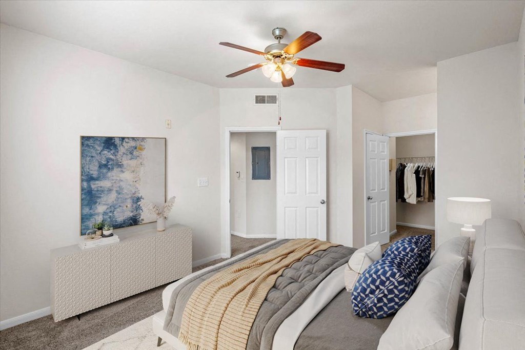 a bedroom with a large bed and a ceiling fan