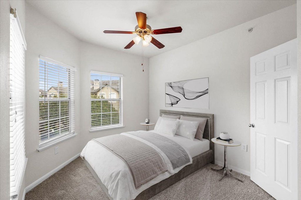 a bedroom with a bed and three windows