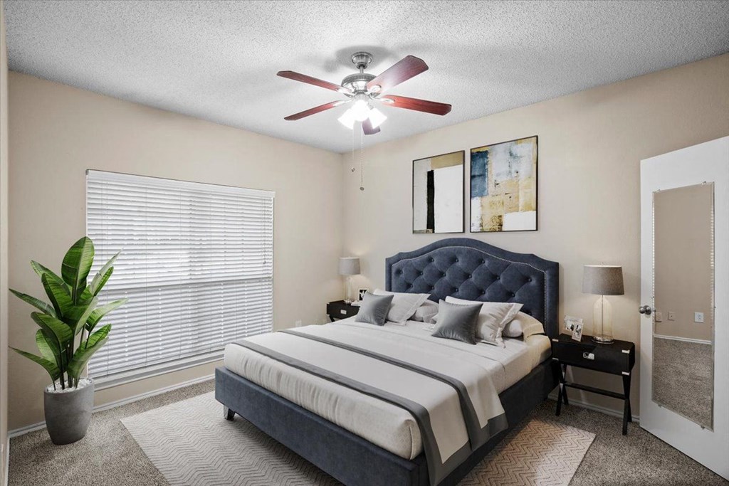 a bedroom with a large bed and a ceiling fan at Creekview Apartment Homes, Dallas, Texas