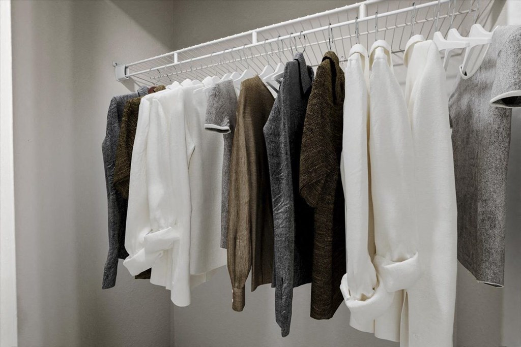 a wardrobe with white clothes and a white hanger at Creekview Apartment Homes, Texas