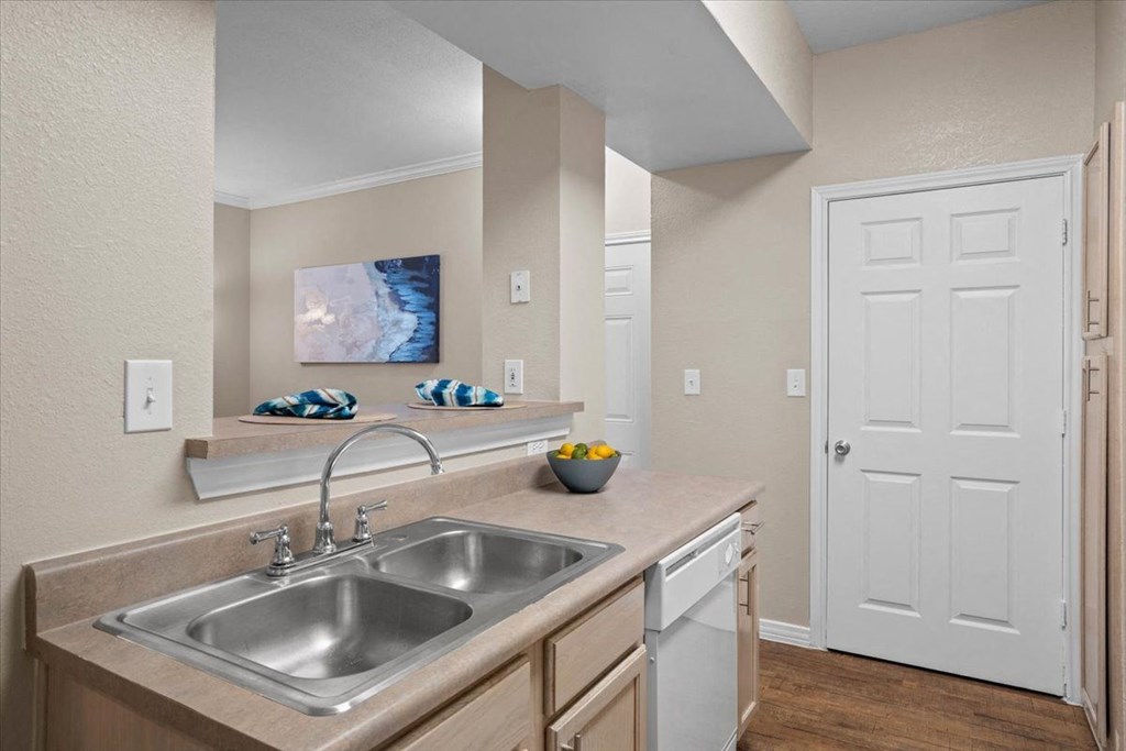 a kitchen with a sink and a dishwasher at The Clairborne Apartment Homes, Texas