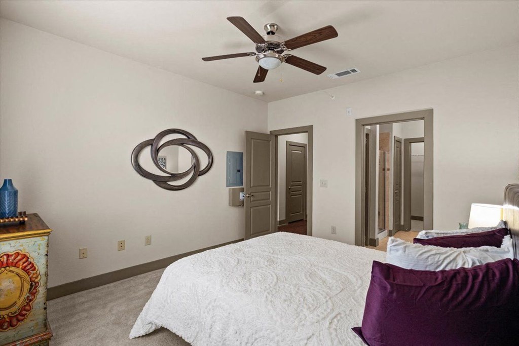 a bedroom with a large bed and a ceiling fanat Cypress at Lewisville Apartment Homes, Lewisville, TX