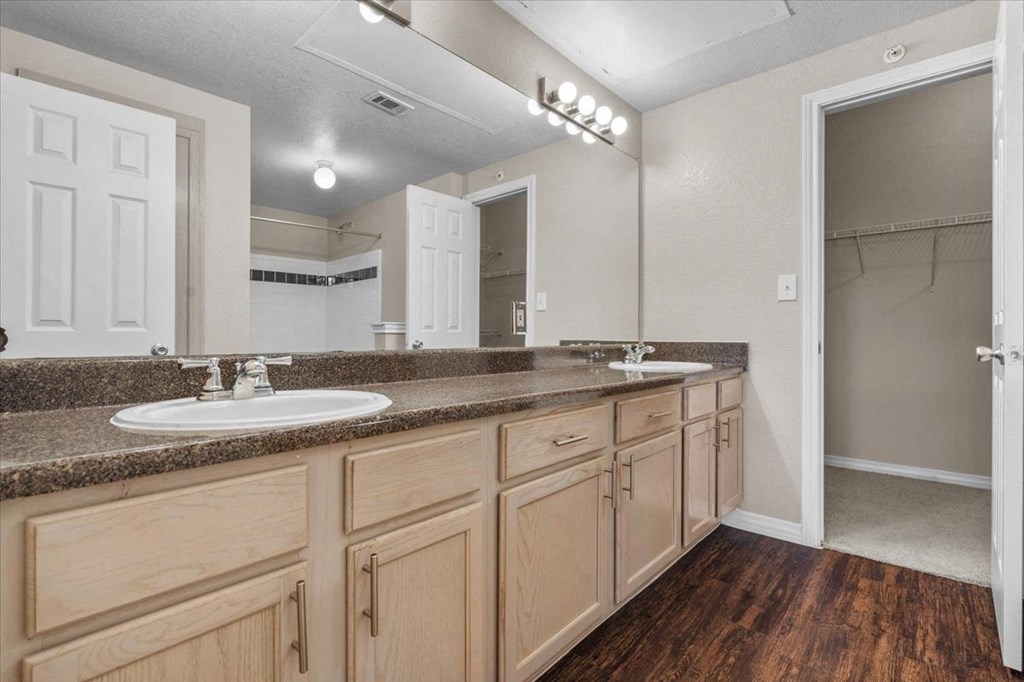 a bathroom with a sink and a mirror at The Clairborne Apartment Homes, Grand Prairie