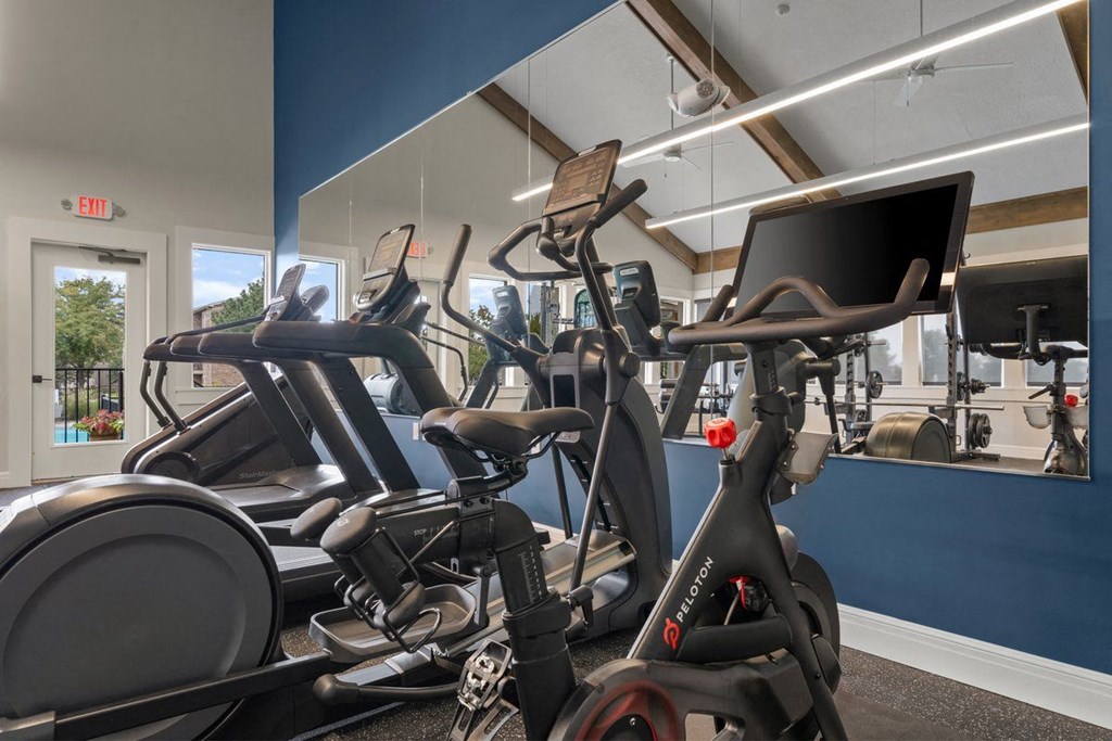 a gym with various exercise bikes and a monitor