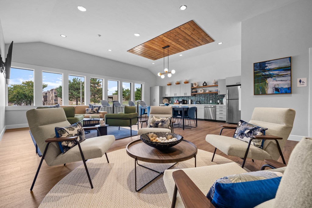 a living room with couches and chairs and a kitchen