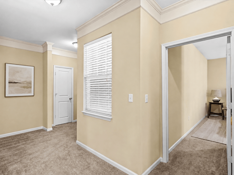 A room with a white door and a window with blinds.