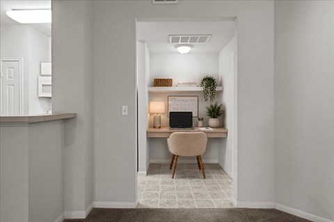 Built-in desk nook with overhead shelf, workspace lighting, and seating area located just off the kitchen in a Crescent Apartments unit.