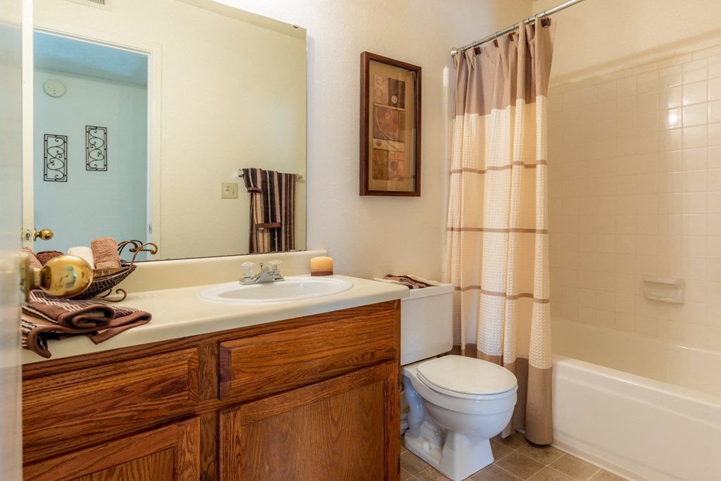 Bathroom with wooden cabinets at Coventry Oaks Apartments, Kansas, 66214