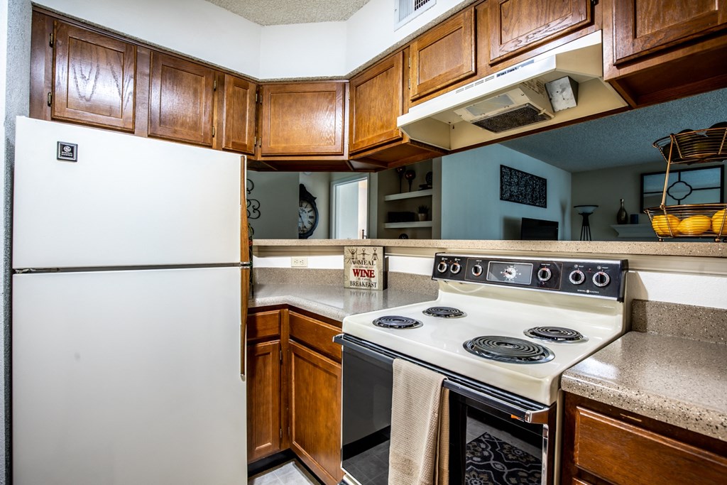 A white refrigerator is in a kitchen with wooden cabinets.