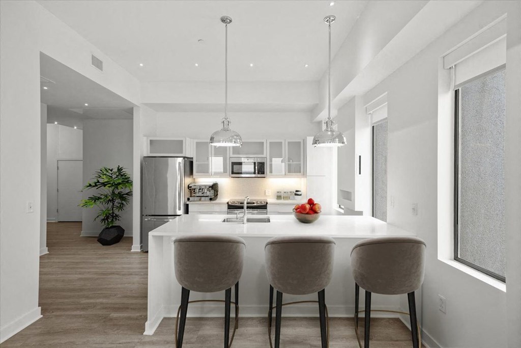 A modern kitchen with a dining table and chairs at Sky On Main Apartments, Missouri City, Missouri