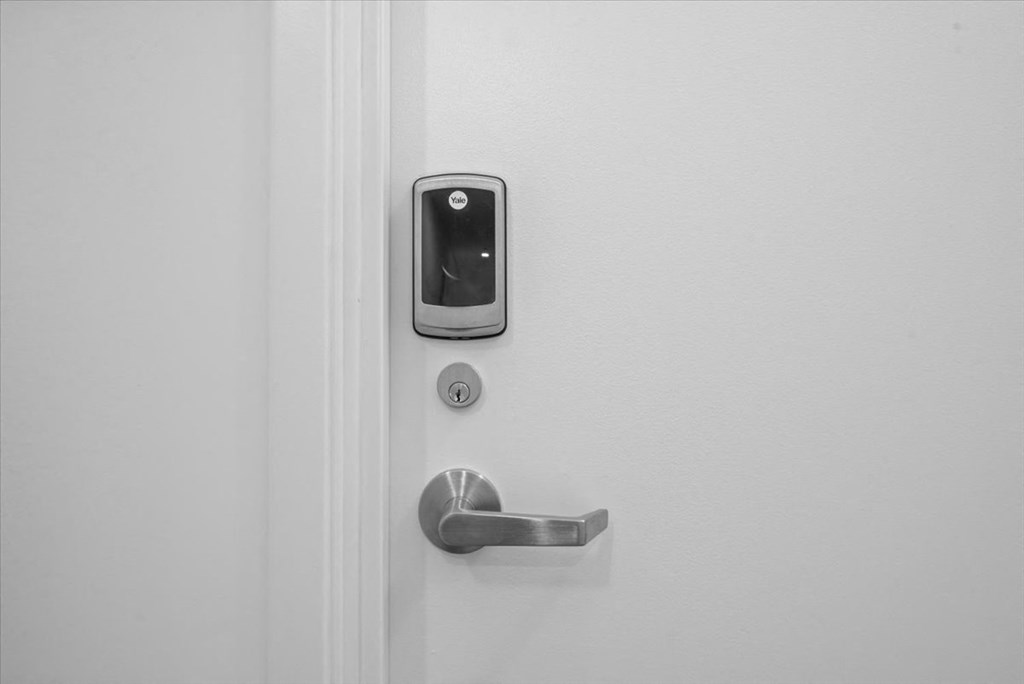 A white door with a silver handle and a keypad lock at Sky On Main Apartments, Missouri City, MO, 64105