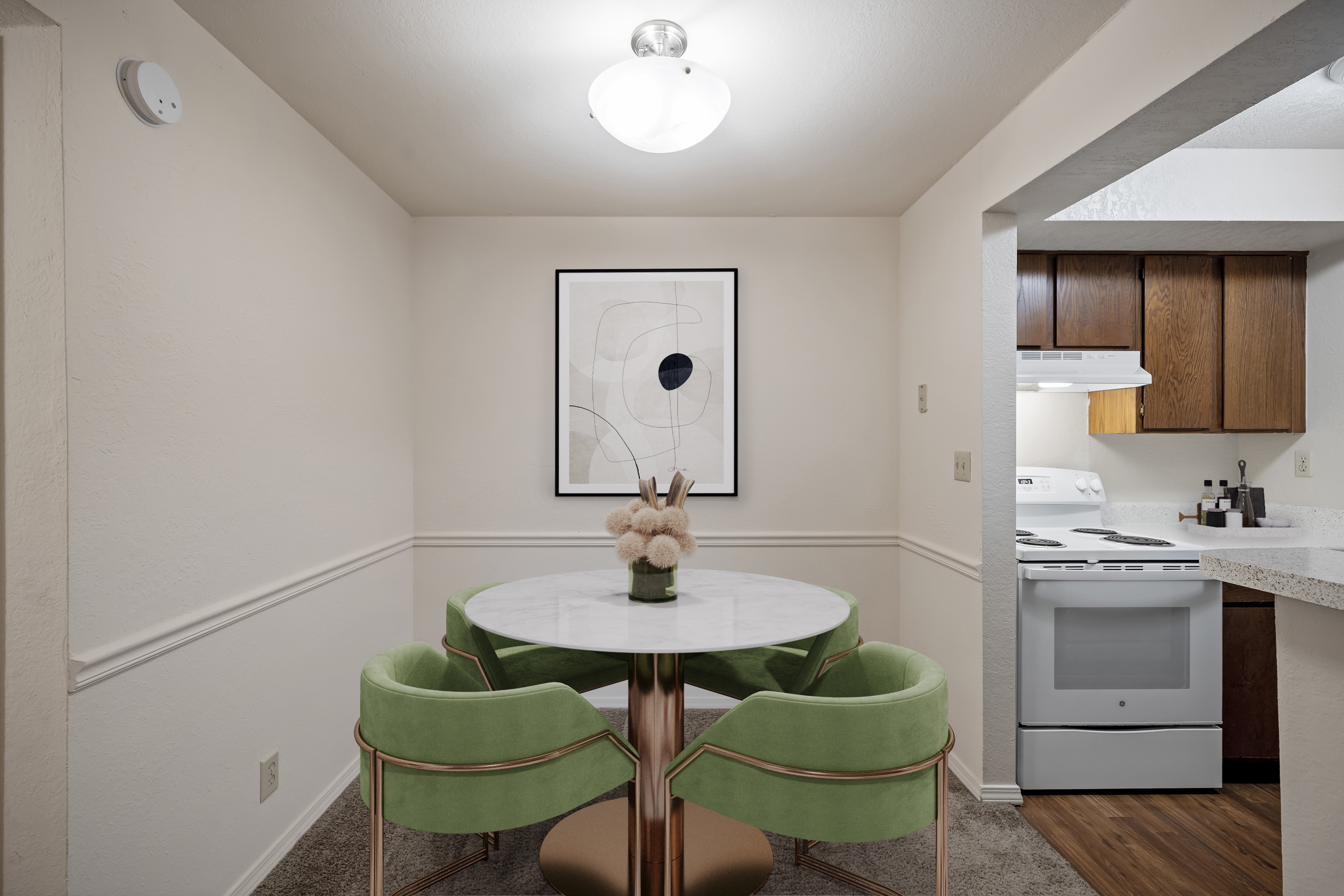 A dining room with a white table and green chairs.