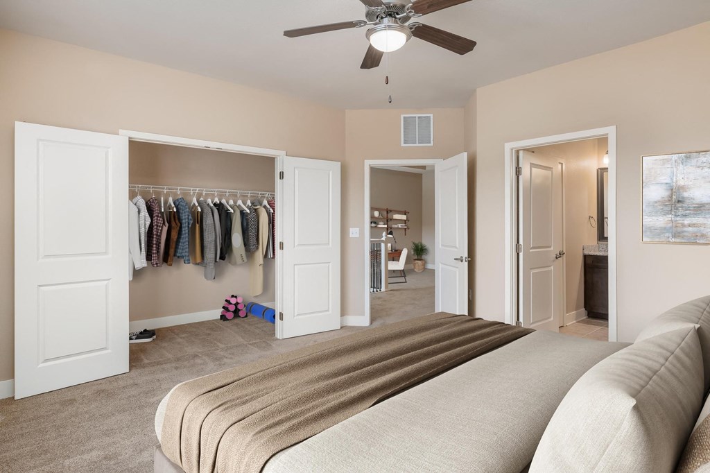 a bedroom with a closet and a bed and a ceiling fan