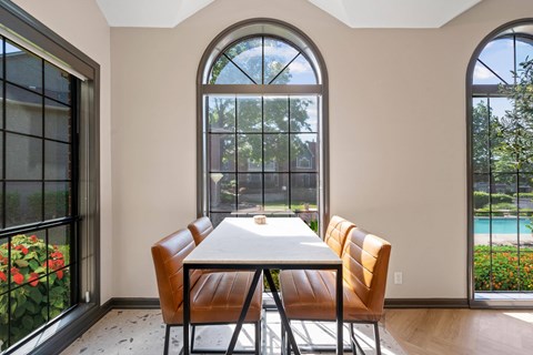 A dining room with a table and chairs.