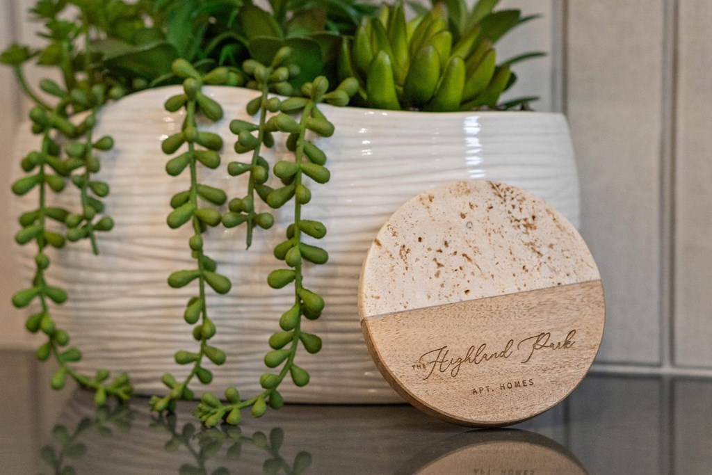 A white ceramic pot with a plant and a wooden box with the text at Highland Park Apartment Homes, Kansas