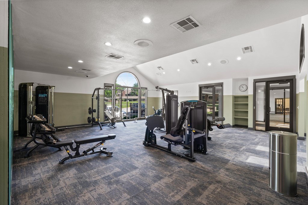 A gym with a variety of equipment including treadmills, weights, and exercise machines. at Highland Park Apartment Homes, Kansas