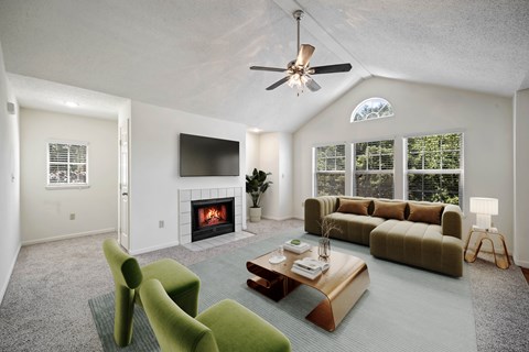 Living room with fireplace, vaulted ceiling, and large windows at Stonebriar Apartments