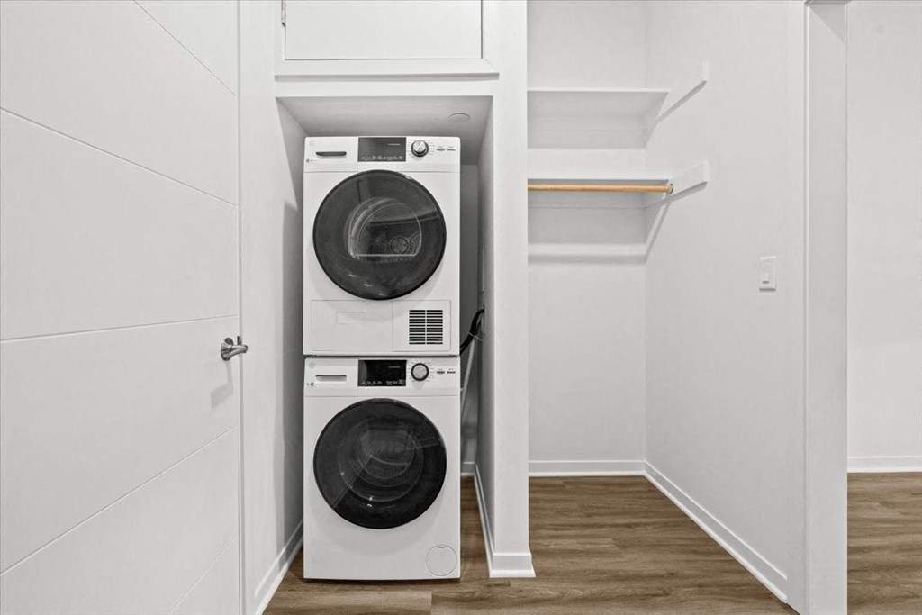 A white washing machine and dryer in a small laundry room at Sky On Main Apartments, Missouri City