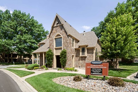 A stone house with a sign in front that says