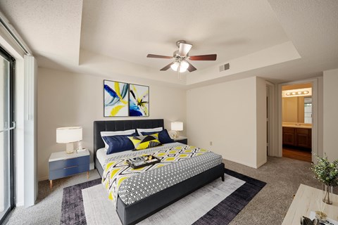 A bedroom with a large bed and a ceiling fan.