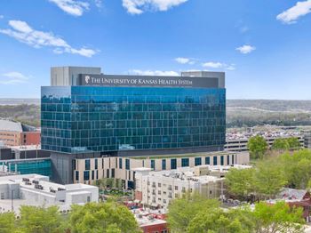 The University of Kansas Health System building is a large, modern structure with a glass facade at Malvern Hill Apartment Homes, 66103 66214
