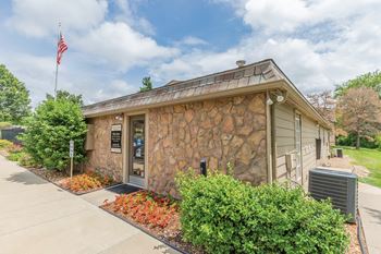 A small building with a flag on top and a stone wall at Bristol Pointe Apartment Homes, Olathe 66062