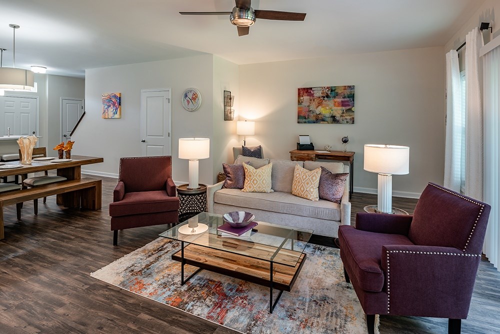 A living room with a couch, two chairs, and a coffee table.