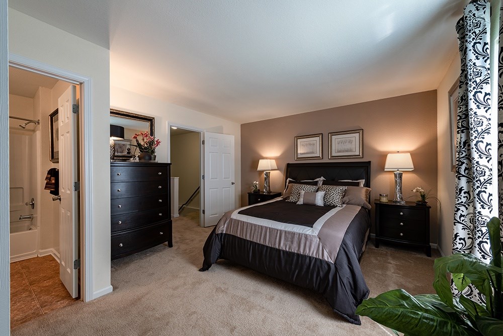 A bedroom with a large bed and a dresser.