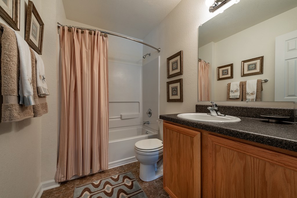 A bathroom with a toilet, sink, and shower.