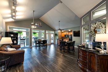 an open concept living room and dining room with hardwood flooring and a vaulted ceiling