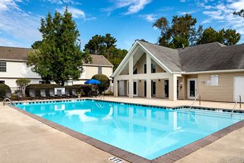 a swimming pool with a house in the background