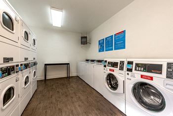 a laundry room with washers and dryers and a table