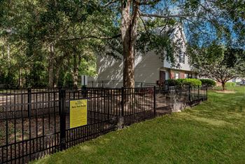 a house behind a fence with a sign on it