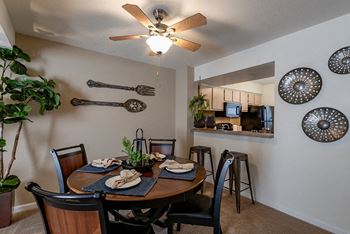our dining room with a table and chairs and a kitchen in the background