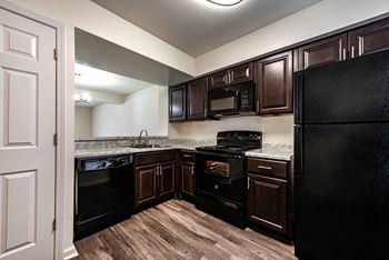 a kitchen with black appliances and wooden cabinets