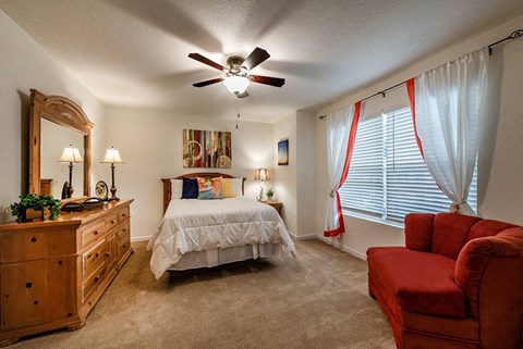 a bedroom with a bed and a ceiling fan
